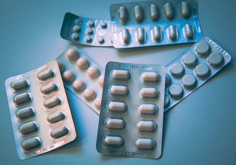 White and yellow supplement capsules on a clean surface