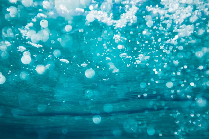 Close-up of ice floating in cold blue water representing cold water immersion therapy