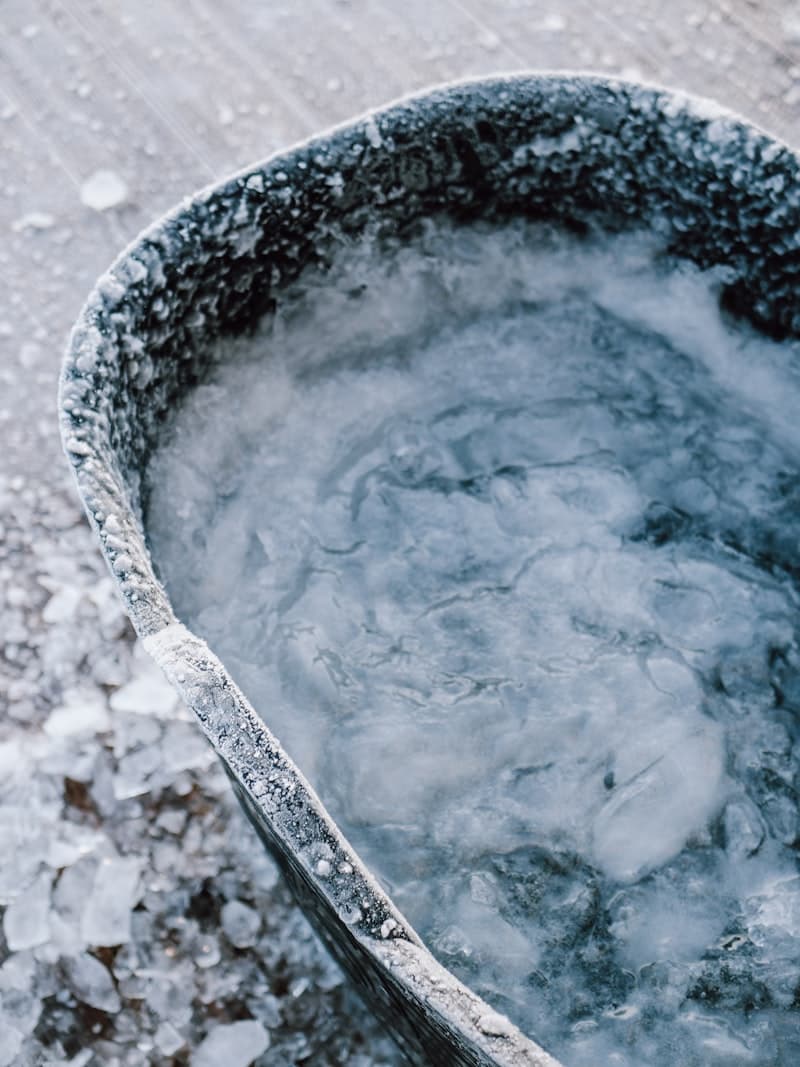 Side-by-side infographic comparing Epsom salt bath vs ice bath across DOMS, inflammation, blood flow, and cost