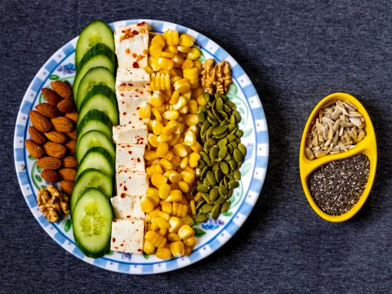 Colorful spread of high protein foods including vegetables, eggs, and lean meats arranged on a table