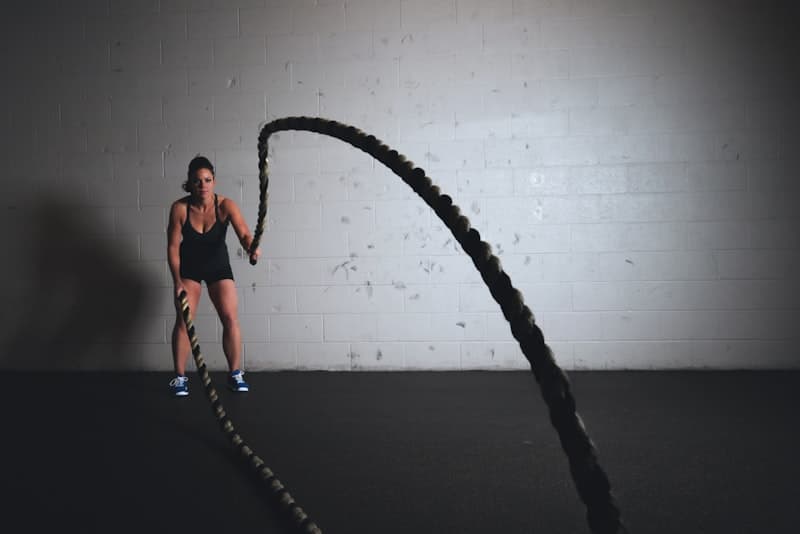 Woman sprinting on treadmill with heart rate monitor — HIIT vs LISS cardio comparison