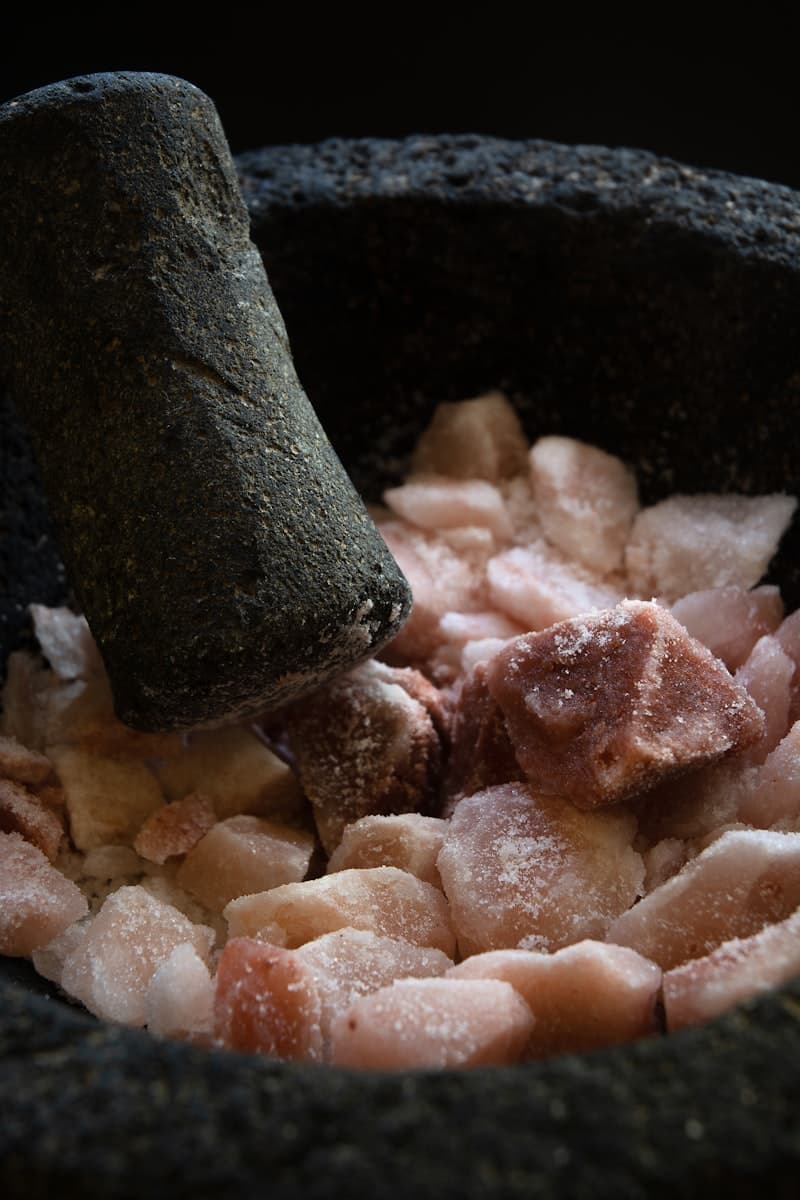 Himalayan pink salt and sea salt side by side in wooden spoons — comparing minerals, sodium, and blood pressure impact