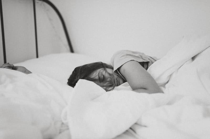 Person relaxing in bed reading with dim lights — building a science-backed sleep routine