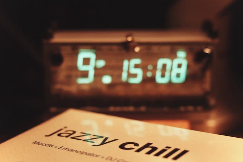 A vintage twin-bell alarm clock resting on a stack of hardcover books