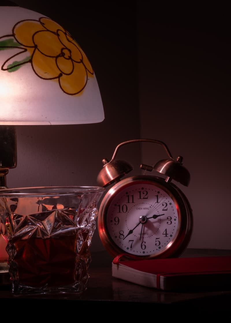 Clock showing 30 to 60 minutes before bed with a glass of water and a magnesium supplement