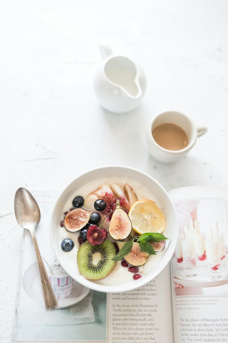 Morning yogurt bowl and coffee on a breakfast table, showing the timing of resveratrol taken with food