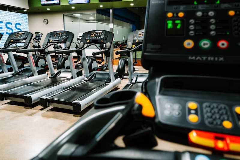 Side-by-side of a treadmill runner and a person lifting weights -- strength vs cardio