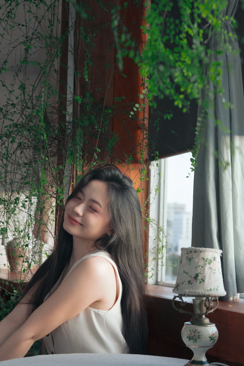 창가에서 눈을 감고 명상하는 젊은 여성 — 차분함과 휴식