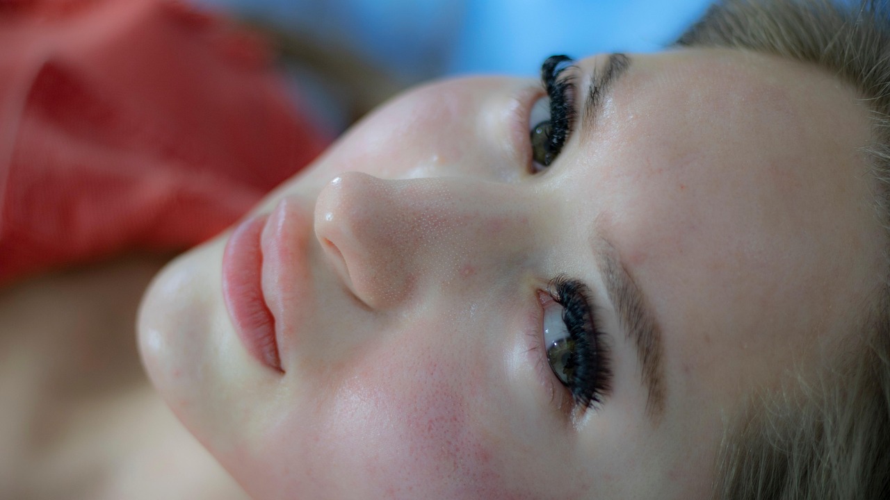 Person receiving red light therapy facial treatment -- collagen production and skin benefits