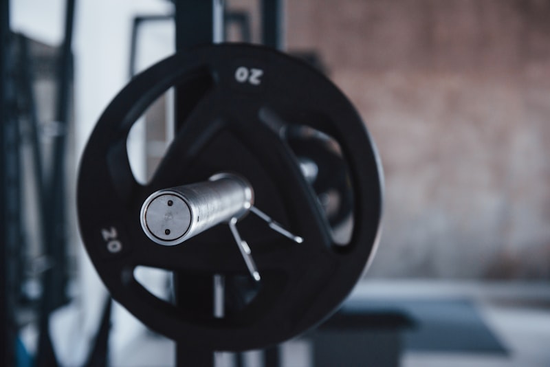 Person preparing to lift a barbell in a gym -- beginner strength training guide hero image